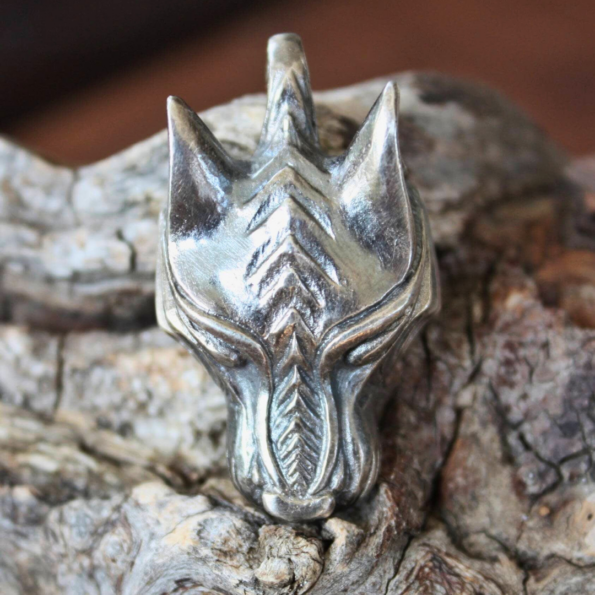 Un detallado colgante vikingo lobo fenrir brillando con su acabado en plata